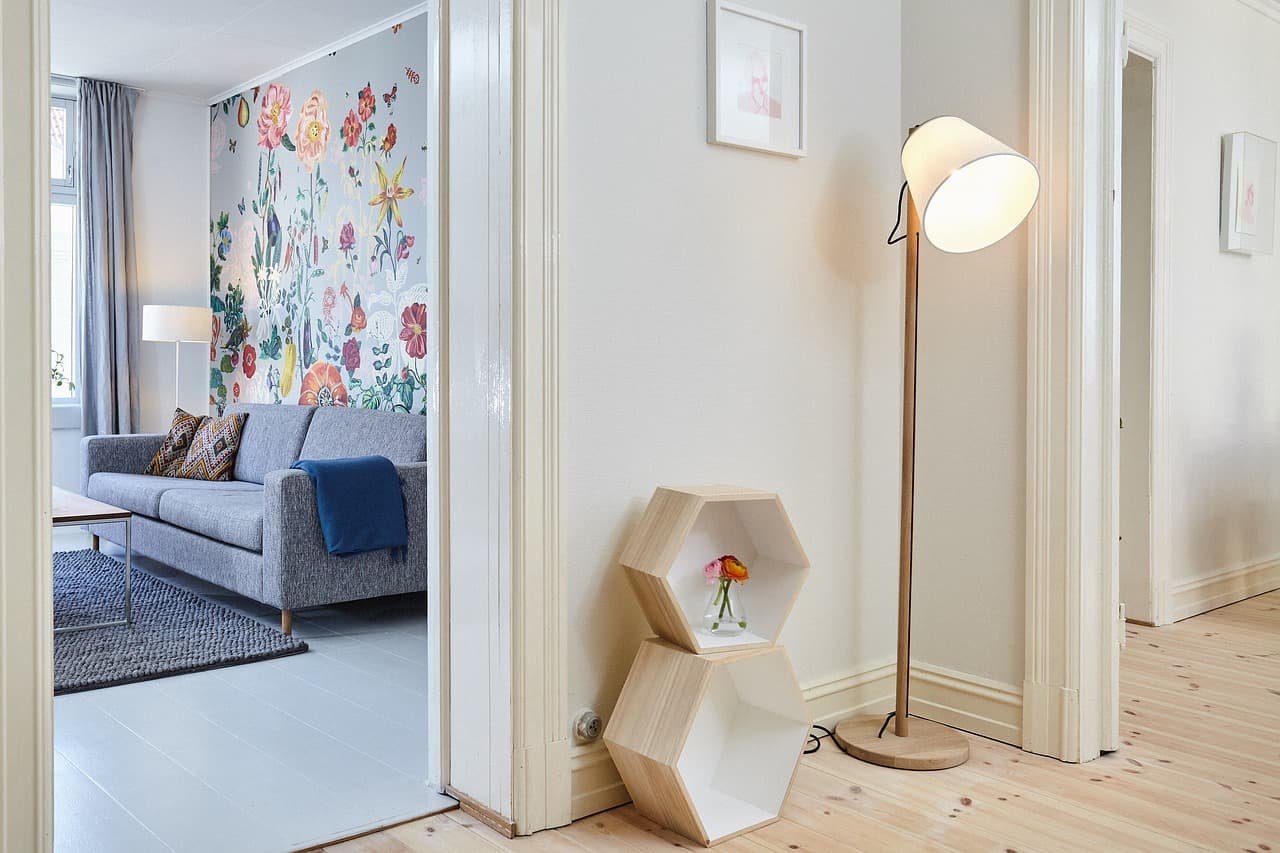 A floral feature wall papered in a living room, seen through an open door
