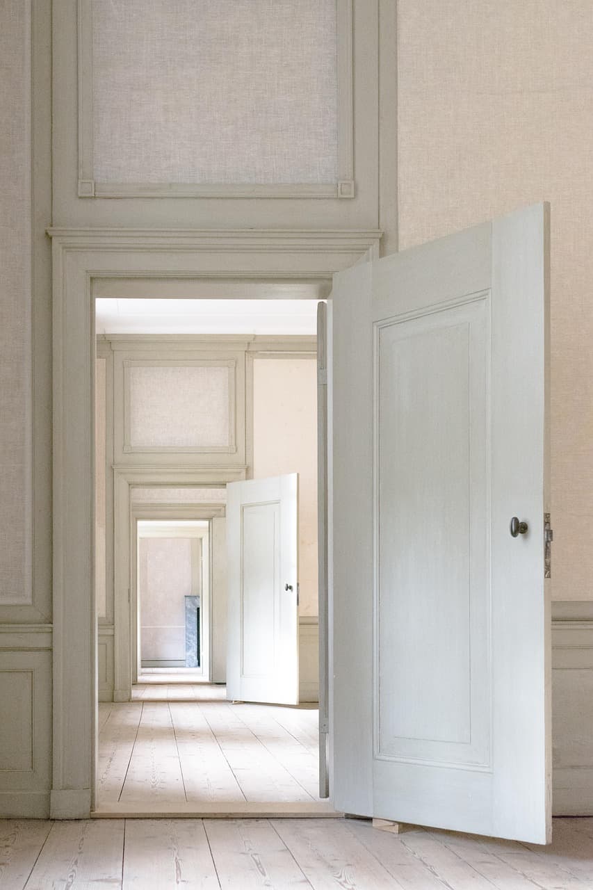 A run of white-painted panelled doors opening one into the next