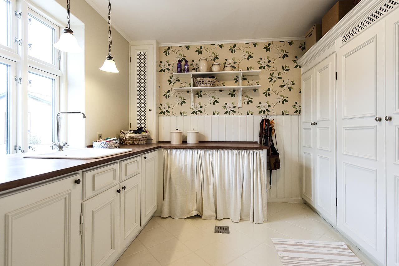 A painted kitchen with a patterned paper behind the open shelves